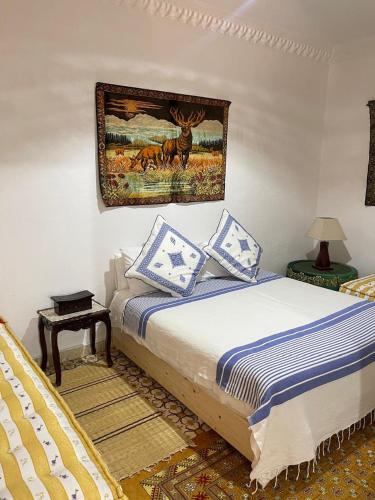 a bedroom with a bed and a picture on the wall at Dar hana in Asilah