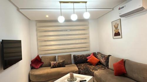 a living room with a couch and a tv at Appartement Haut standing-coralia,centre ville oujda in Oujda