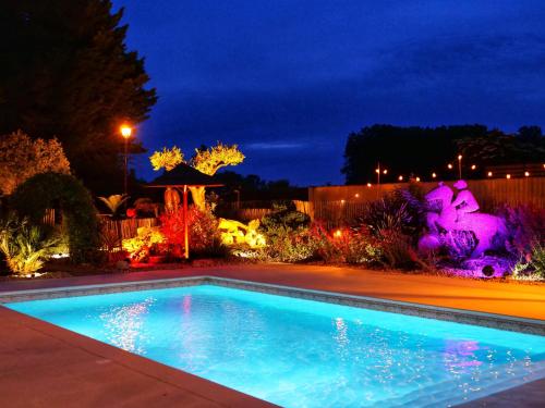 a swimming pool in a yard at night at Cottage avec piscine au cœur du Saumur Champigny in Souzay-Champigny