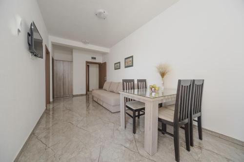a living room with a table and chairs and a couch at Apartmani Agape in Petrovac na Moru