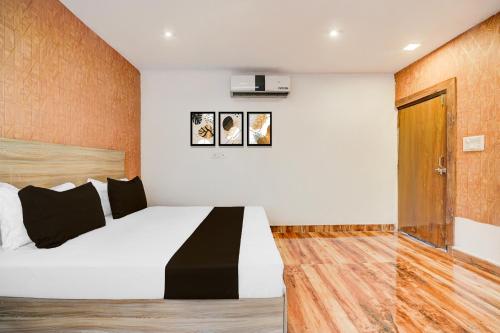 a bedroom with a white bed with black and white pillows at Hotel O P2 in Bhopal