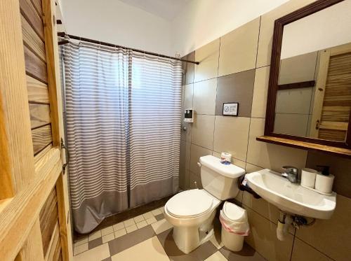 a bathroom with a toilet and a sink at Surfbreak B&B in Cabarete
