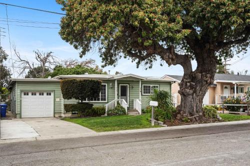 a green house with a tree in front of it at O-Side Beach Bungalow with Jaccuzi Blocks to beach in Oceanside