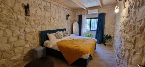 a bedroom with a bed in a stone wall at Iris 2 BR Apartment In Batroun in Batroûn