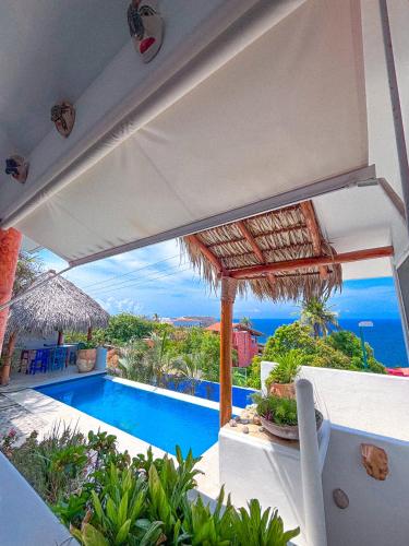 a view of a swimming pool with an umbrella at Villa Ballam 3, Balcones, bahías de Huatulco, Oax in Tangolunda