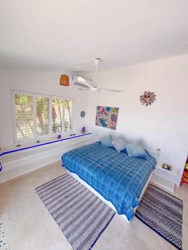 a bedroom with a blue bed and a window at Villa Ballam 3, Balcones, bahías de Huatulco, Oax in Tangolunda
