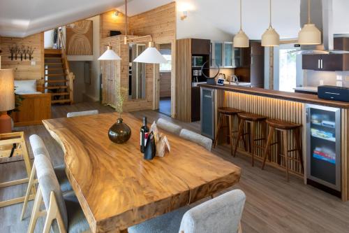 a kitchen and dining room with a wooden table at 300ft Modern Luxury Lakefront Hot Tub Steam Bath in Miller Lake