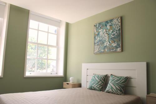a bedroom with a bed and a window at Alfred Studio in Guimarães