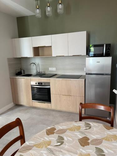 une cuisine avec une table, des chaises et un réfrigérateur dans l'établissement La casuccia Galliéni, à Rochefort