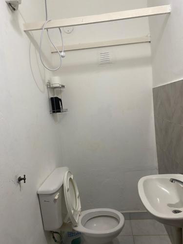 a white bathroom with a toilet and a sink at Departamento V&S in Posadas