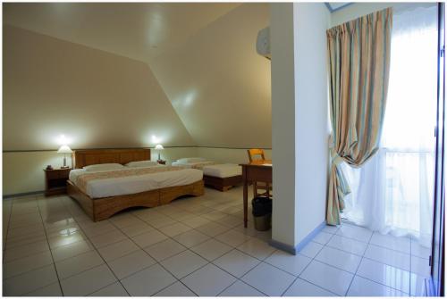 a hotel room with a bed and a window at La Fournaise Hotel Restaurant in Sainte-Rose