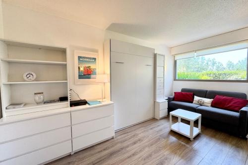 un salon avec un canapé et une fenêtre dans l'établissement Escapade à Carnac Piscine & à 2 pas de la mer, à Carnac