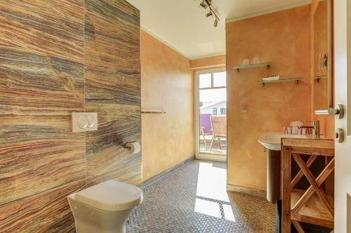 a bathroom with a toilet and a sink at Strandvilla Börgerende in Börgerende-Rethwisch