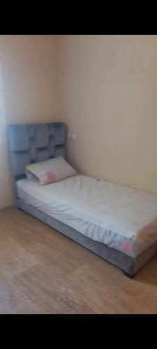 a bed with a blue headboard in a room at Apartamento en Rabat al lado del Mar in Oulad Akkou
