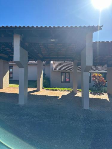 a large pergola in front of a house at BlueHive guesthouse Leisure in Port Edward