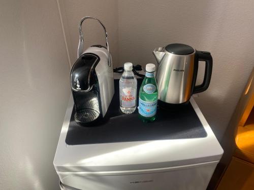 a refrigerator with a tea kettle and two bottles of water at Casa Franca - Vacation Apartment in San Pellegrino Terme