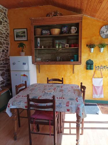 une table et des chaises dans une cuisine avec une horloge dans l'établissement Maison de pêcheur, à Perros-Guirec