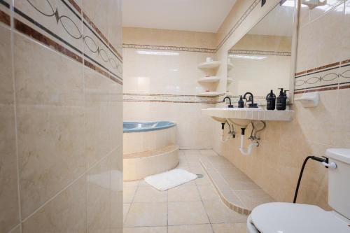 a bathroom with a sink and a tub and a toilet at BnB rooms in downtown Cancun- Casa Sunshine Cancun in Cancún