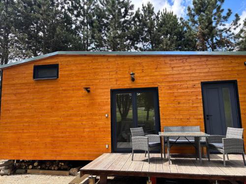 a building with a table and chairs on a deck at TINY HOUSE - Karlovarský kraj Loket in Staré Sedlo