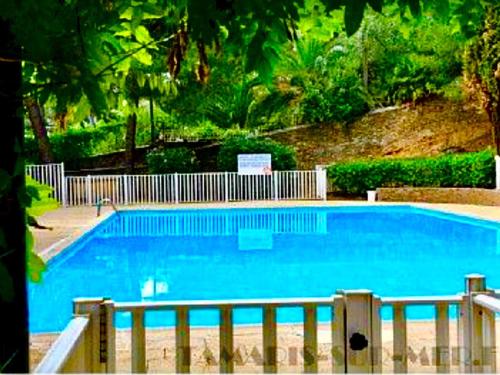 une grande piscine bleue à côté d'une clôture dans l'établissement Studio Standing Port Tamaris, à La Seyne-sur-Mer