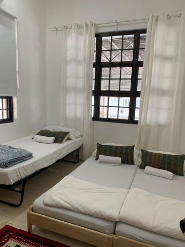 a bedroom with two beds and a window at Casa Syukur in Cukai