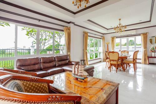 a living room with a couch and a table at Luxury Iconic Royal Boat Pool Villa North Pattaya in Pattaya
