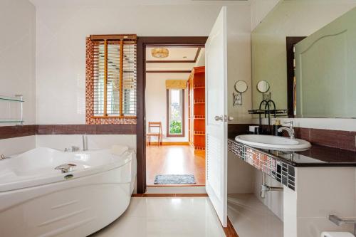 a bathroom with a white tub and a sink at Luxury Iconic Royal Boat Pool Villa North Pattaya in Pattaya Central