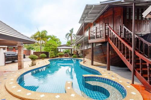 a swimming pool in front of a building with a staircase at Luxury Iconic Royal Boat Pool Villa North Pattaya in Pattaya