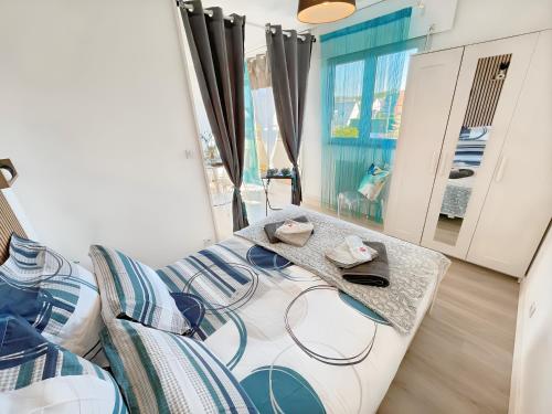 une chambre avec un lit, une table et un miroir dans l'établissement La croisette - à 50 mètres de la plage de Juno Beach avec Balcon et Stationnement gratuit, à Bernières-sur-Mer