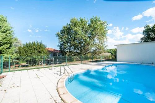 une piscine dans une cour clôturée dans l'établissement Magnifique maison avec piscine, à Bon-Encontre
