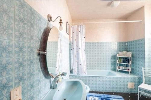 ein Badezimmer mit Badewanne, Waschbecken und Spiegel in der Unterkunft Magnifique maison avec piscine in Bon-Encontre