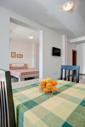 a table with a bowl of oranges on top of it at Apartmani Agape in Petrovac na Moru