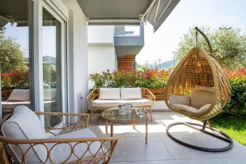 a porch with two chairs and a swing at Ethra Apartment T in Skala Rachoniou