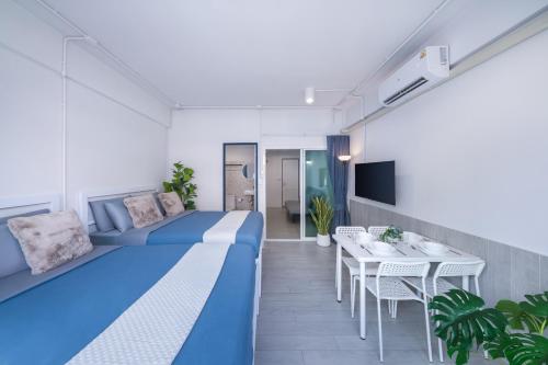 a hotel room with a blue bed and a table at Petchaburi22 Apartments next to Platinum mall in Bangkok