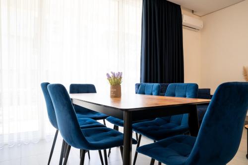 a conference room with a table and blue chairs at Gjiri i Lalzit - San Pietro - Leta's Premium Apartments in Lalzit Bay