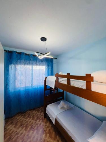 a room with two bunk beds and a blue wall at Beachfront Bliss Central 2BR Apartment in Durrës