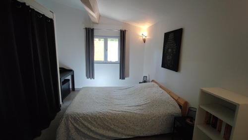 a bedroom with a bed and a window at Maisonnette presqu ile de Giens in Hyères