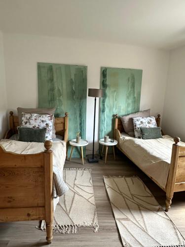 a bedroom with two beds and a lamp at EifelZeit 1 in Kall