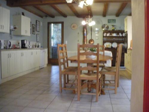 een keuken en eetkamer met een tafel en stoelen bij Le Grenier 1 Rue Verte Tusson 16140 France in Tusson