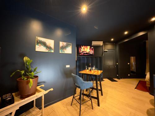 une pièce avec une table et une télévision sur un mur dans l'établissement Mieuxqualhotel jacuzzi privatif La Parenthèse, à Bordeaux