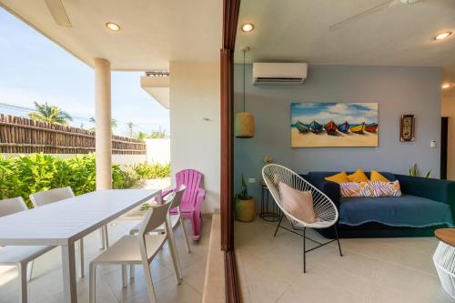 a dining room and living room with a table and chairs at Hermoso Departamento En la Playa in Chicxulub
