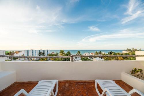 a balcony with chairs and a view of the ocean at Hermoso Departamento En la Playa in Chicxulub