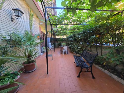 a patio with a bench and trees and plants at Casa ELLA in Rome