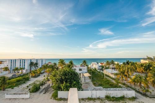 a view of a beach with palm trees and the ocean at Hermoso Departamento En la Playa in Chicxulub