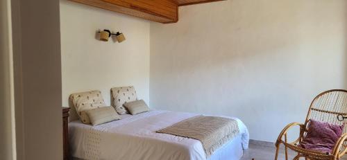 une chambre avec un lit et deux chaises dans l'établissement Très charmante maison de ville au coeur du village, à Murato