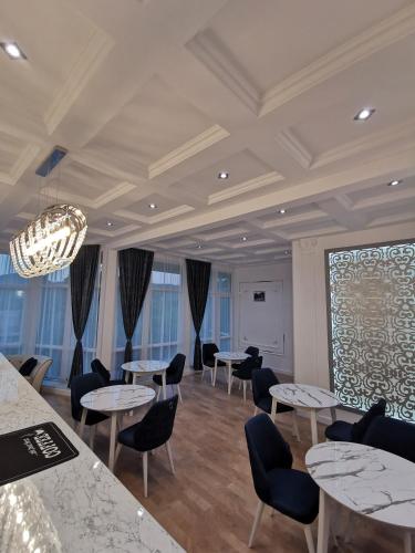 a room with tables and chairs and a large window at Holiday inn Adnan boutique hotel and pool in Gabala