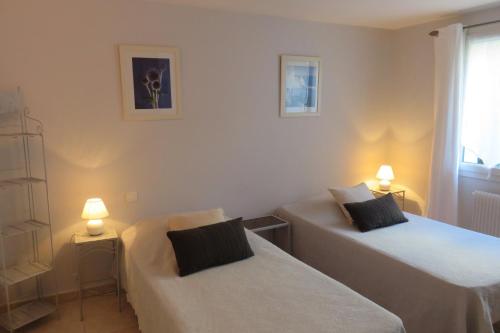 - 2 lits dans une chambre avec 2 lampes et une fenêtre dans l'établissement La Péguière, à Saint-Raphaël