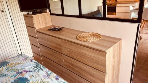 - une commode en bois dans une chambre avec un miroir dans l'établissement Appt Hôtel Albatros près côte d'azur, piscine, parking privé, proche du Golf St Donat, à Mouans-Sartoux