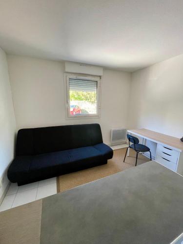- un salon avec un canapé noir et un bureau dans l'établissement Studio cosy, lumineux Avignon, à Avignon