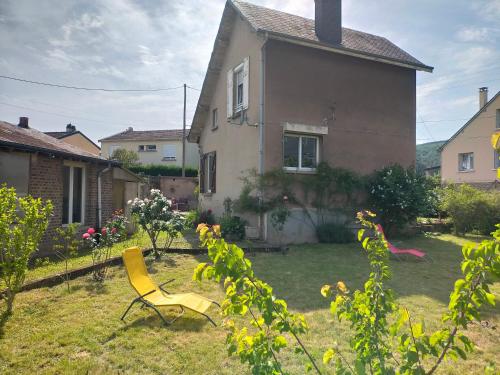 een gele stoel in de tuin van een huis bij B.B.Home in Revin